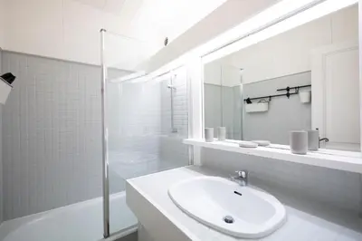a white bathroom with a sink and a mirror at Studio rénové dans le centre piéton de Megève in Megève