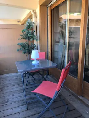 a table and two chairs on a porch at Studio rénové dans le centre piéton de Megève in Megève