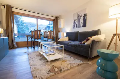 a living room with a couch and a table at Studio rénové dans le centre piéton de Megève in Megève