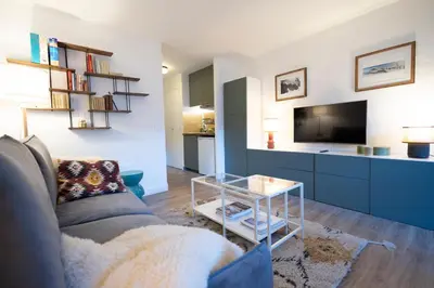 a living room with a couch and a tv at Studio rénové dans le centre piéton de Megève in Megève