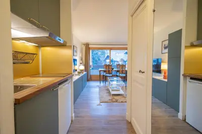 a kitchen with blue cabinets and a dining room at Studio rénové dans le centre piéton de Megève in Megève