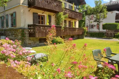 a garden with pink flowers and a house at Appartement confortable à Megève | 46m² | Vue sur montagne in Megève