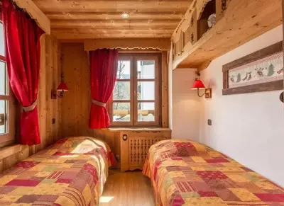 two beds in a room with a window at Appartement confortable à Megève | 46m² | Vue sur montagne in Megève
