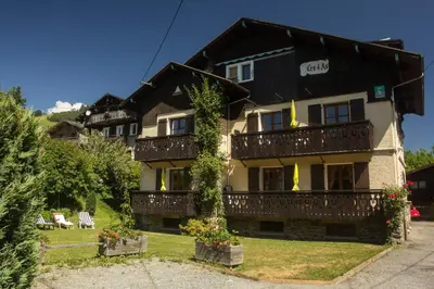 a large house with ivy on the front of it at Appartement confortable à Megève | 46m² | Vue sur montagne in Megève