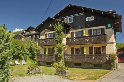 a large house with a balcony with plants at Appartement confortable à Megève | 46m² | Vue sur montagne in Megève