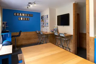 a dining room with tables and chairs and a blue wall at Chamonix Lodge in Chamonix-Mont-Blanc