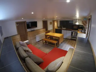 a large living room with a couch and a kitchen at Chamonix Lodge in Chamonix-Mont-Blanc