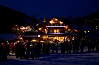 a crowd of people standing in front of a building at night at Hotel Le Christiania in Les Contamines-Montjoie