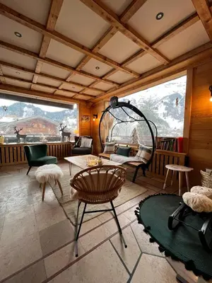 a living room with a table and chairs in a room at Hotel Le Christiania in Les Contamines-Montjoie