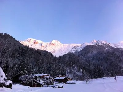 a snow covered mountain with a cabin in the foreground at Hotel Le Christiania in Les Contamines-Montjoie