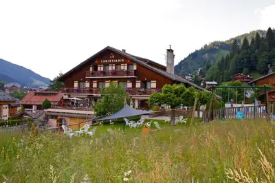 a large building with tables and chairs in a field at Hotel Le Christiania in Les Contamines-Montjoie