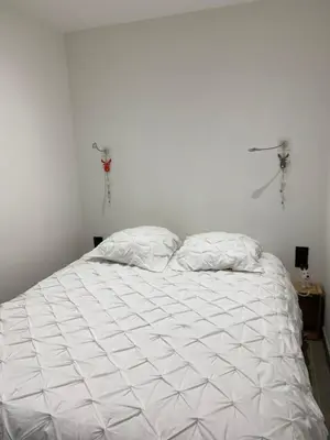 a white bed with two pillows in a bedroom at MONT BLANC HOLIDAYS dans résidence avec Gardien in Sallanches