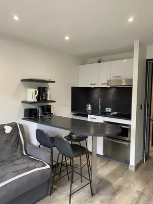 a kitchen with a table and chairs and a couch at MONT BLANC HOLIDAYS dans résidence avec Gardien in Sallanches