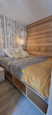 a bedroom with a bed with a wooden headboard at Elégant et moderne, au pied du Mont-Blanc in Saint-Gervais-les-Bains