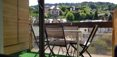 a table and chairs on a balcony with a view at Elégant et moderne, au pied du Mont-Blanc in Saint-Gervais-les-Bains