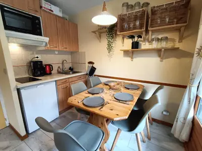 a kitchen with a table and chairs in a kitchen at Nice & cozy apartment facing the gondola - LA BOULE DE NEIGE 112 in Les Contamines-Montjoie