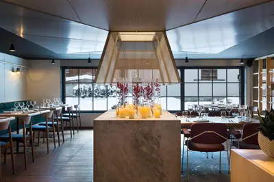 a restaurant with tables and chairs and a chandelier at Heliopic Hotel & Spa in Chamonix-Mont-Blanc