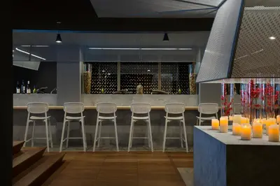 a bar in a restaurant with stools and orange candles at Heliopic Hotel & Spa in Chamonix-Mont-Blanc