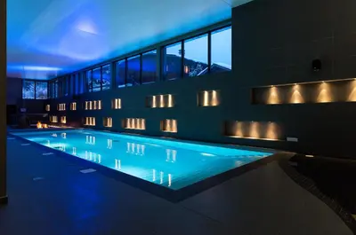 a swimming pool in a building with blue lights at Heliopic Hotel & Spa in Chamonix-Mont-Blanc