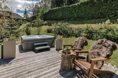 a wooden deck with a hot tub and a bench at Le Hameau du Renard Blanc in Saint-Gervais-les-Bains