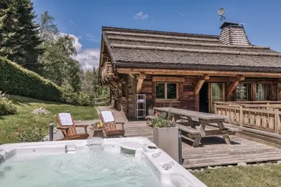 a log cabin with a hot tub in the yard at Le Hameau du Renard Blanc in Saint-Gervais-les-Bains