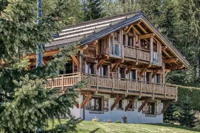 a log cabin with a wrap around porch at Le Hameau du Renard Blanc in Saint-Gervais-les-Bains