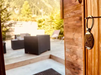 an open door with a television on a patio at Chalet le petit Nicolas, jacuzzi, vue Mont Blanc in Chamonix-Mont-Blanc
