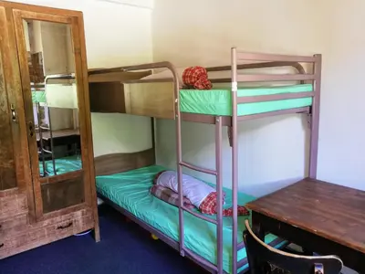 a room with bunk beds with a table and a mirror at Le Chamoniard Volant in Chamonix-Mont-Blanc