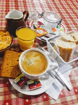 a table topped with a cup of soup and bread at Le Chamoniard Volant in Chamonix-Mont-Blanc