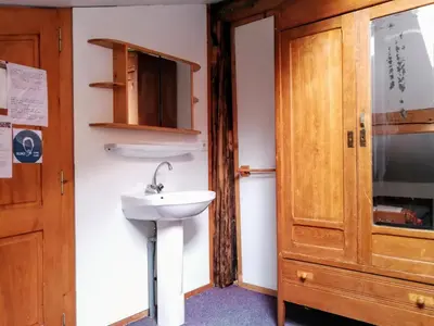 a bathroom with a sink and a wooden cabinet at Le Chamoniard Volant in Chamonix-Mont-Blanc