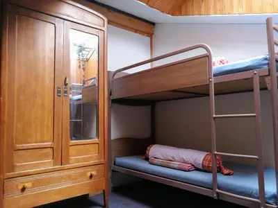 a bunk bed room with two bunk beds and a cabinet at Le Chamoniard Volant in Chamonix-Mont-Blanc