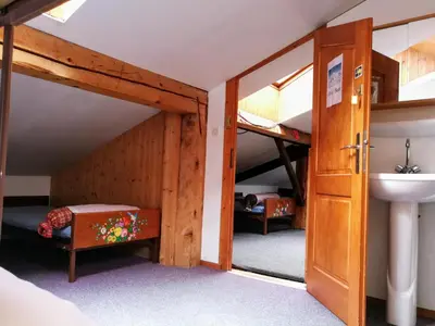 a room with bunk beds and a sink and a door at Le Chamoniard Volant in Chamonix-Mont-Blanc