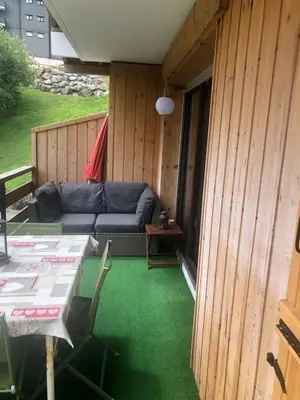a balcony with a bed and a table and chairs at Studio Turquoise quartier Grattague vue MontBlanc in Saint-Gervais-les-Bains