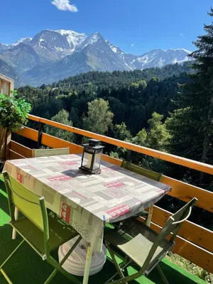 a living room with a couch and a table at Studio Turquoise quartier Grattague vue MontBlanc in Saint-Gervais-les-Bains