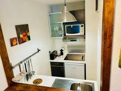 a small kitchen with a sink and a microwave at Appt cosy au centre de Chamonix in Chamonix-Mont-Blanc