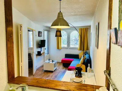 a living room with a blue couch and a mirror at Appt cosy au centre de Chamonix in Chamonix-Mont-Blanc