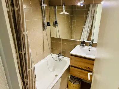 a bathroom with a sink and a tub and a toilet at Appt cosy au centre de Chamonix in Chamonix-Mont-Blanc