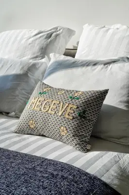 a bed with a pillow with the word welcome at La Ménandière in Megève