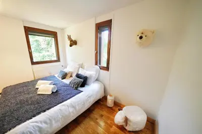 a bedroom with a bed with a blue blanket at La Ménandière in Megève