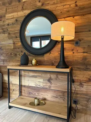 a table with a lamp and a mirror on a wall at Appartement style chalet avec grande terrasse et parking prive in Chamonix-Mont-Blanc