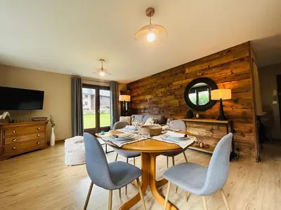 a dining room with a table and chairs and a mirror at Appartement style chalet avec grande terrasse et parking prive in Chamonix-Mont-Blanc