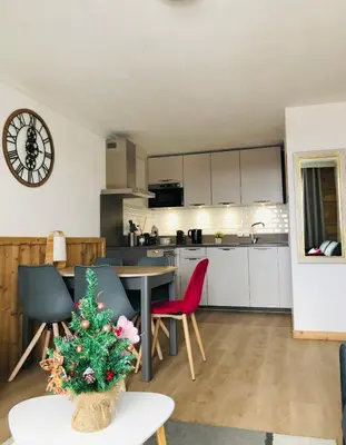 a kitchen and living room with a christmas tree in a room at Mont Blanc 43, vue Mont Blanc , balcon, parking in Chamonix-Mont-Blanc