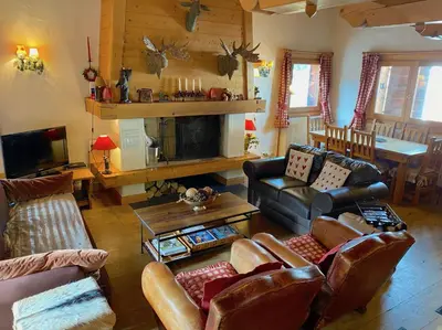 a kitchen and living room with a table and chairs at Chalet Roseau in Megève