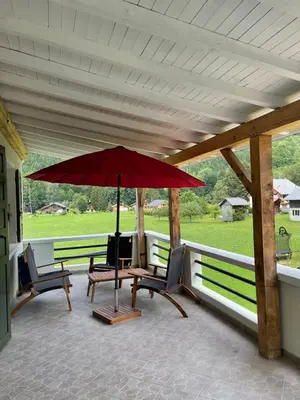 a patio with a table and chairs and an umbrella at Nant d Ant in Samoëns
