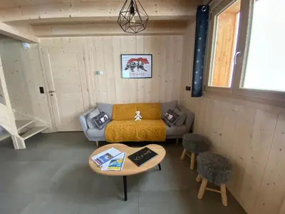a living room with a couch and a table at Les Ours de Combloux in Combloux
