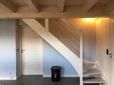 an attic room with wooden stairs and a trash can at Les Ours de Combloux in Combloux