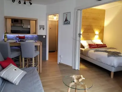 a bedroom with a bed and a table and a kitchen at Chamonix sud -Le Grepon in Chamonix-Mont-Blanc