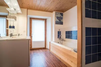 a large bathroom with a tub and a sink at Appartement spacieux proche des télécabines et du centre ville avec jardin privé in Saint-Gervais-les-Bains