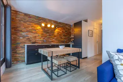 a kitchen with a table and a brick wall at Appartement Cham-Vue in Chamonix-Mont-Blanc