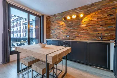 a kitchen with a wooden table and a brick wall at Appartement Cham-Vue in Chamonix-Mont-Blanc